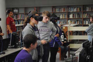 One of Kaser's STEM VR students assists a pair students in the health class.  Both students go through the experience, with the student in the headset relaying information to the person taking notes on a computer.