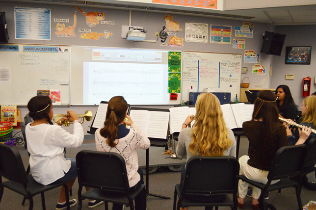 Music teachers at Oak View Middle School use an interactive projector to display a score, and students use an app that tells them if they are sharp or flat.