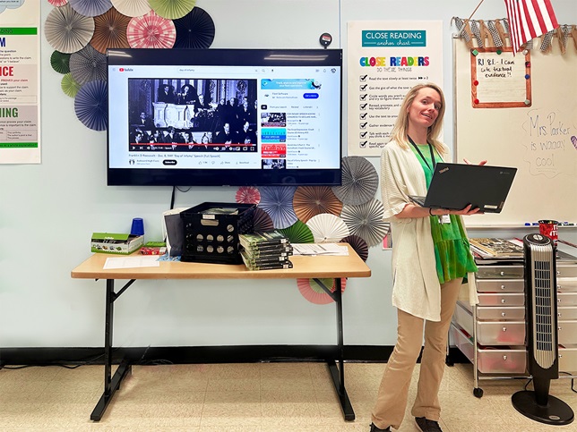 A Warren County Public Schools teacher in Bowling Green, Kentucky, stands in a classroom with her laptop that is wirelessly shared on a TV using the Airtame platform