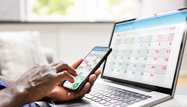 closeup of laptop and smartphone calendars