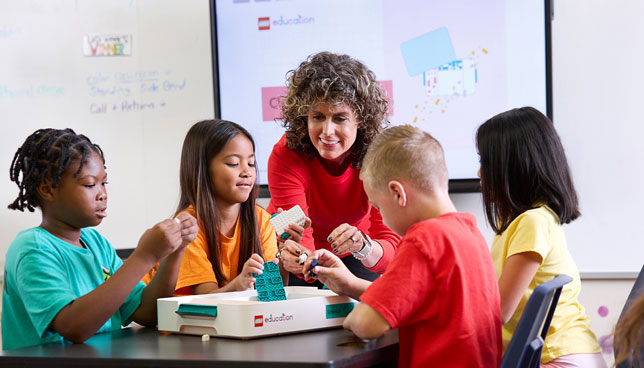 teacher and children working with a LEGO Education Science kit