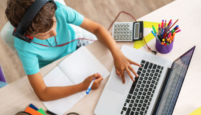boy using laptop and headphones studying math