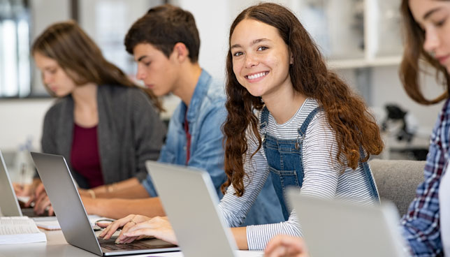 high school students working on laptops