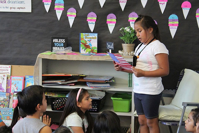 A New River Elementary third-grade student presents her project while using a microphone that will project her voice in the classroom.